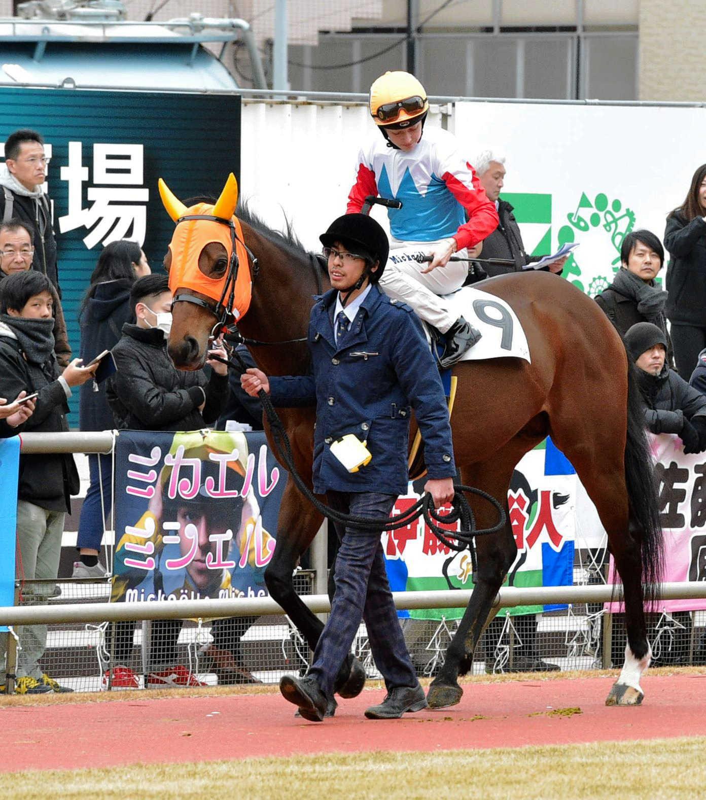 　パドックに掲げられた横断幕とヨイチビームに騎乗するミカエル・ミシェル（撮影・持木克友）